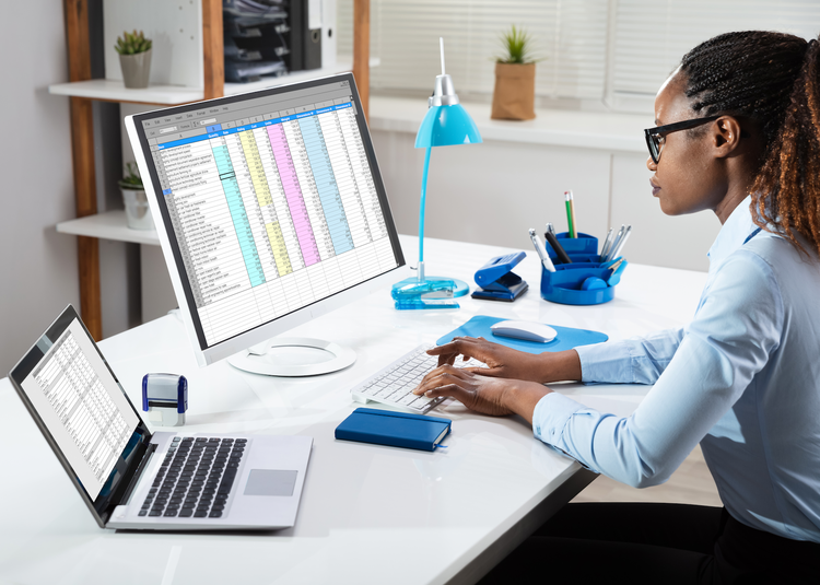 Side View Of Businesswoman's Hand Analyzing Data On Computer Over Desk