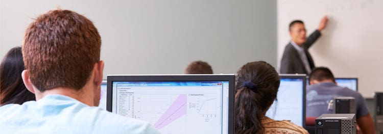 建标 John Pan 与学生在计算机教室中